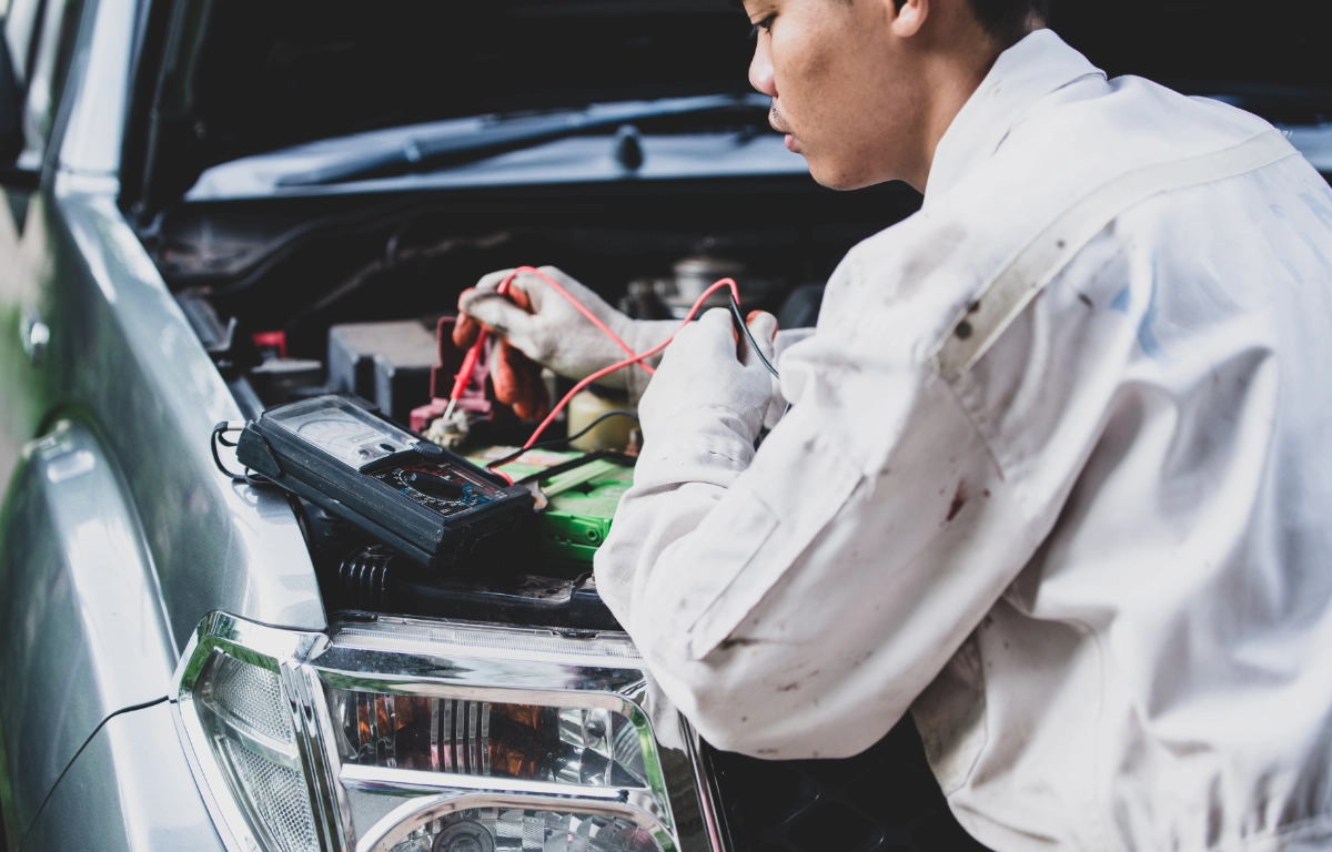 Mechanik naprawiający instalację elektryczną samochodu w serwisie Lubliniec