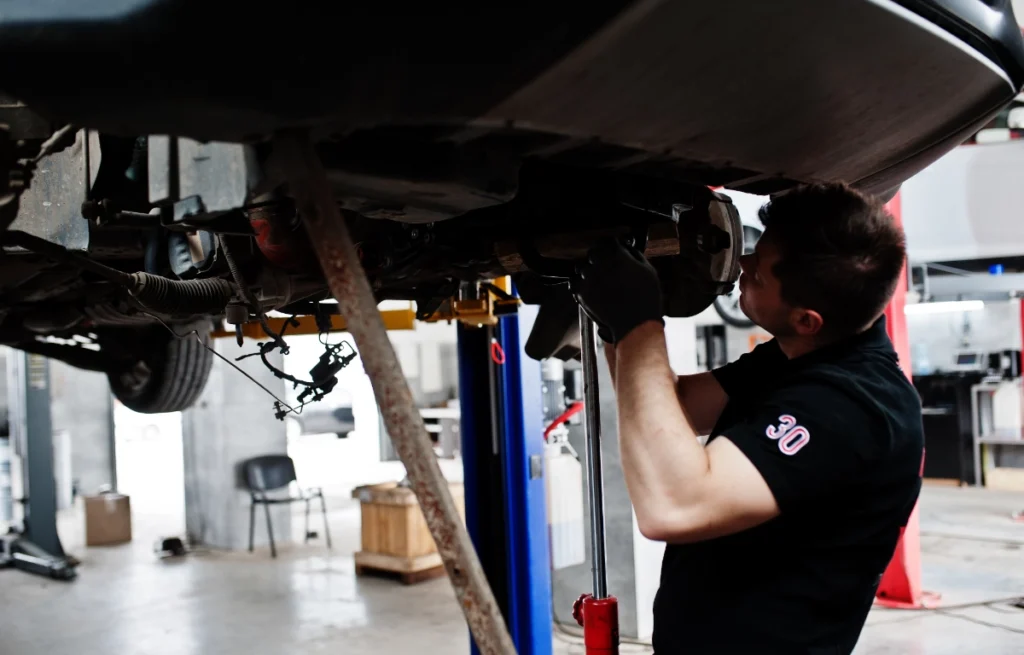 Wahacze, sworznie i tuleje Zużyty sworzeń wahacza wymieniany przez mechanika w serwisie samochodowym Lubliniec