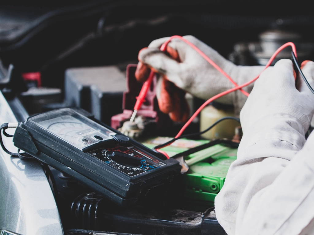 Mechanik naprawiający instalację elektryczną samochodu w serwisie Lubliniec